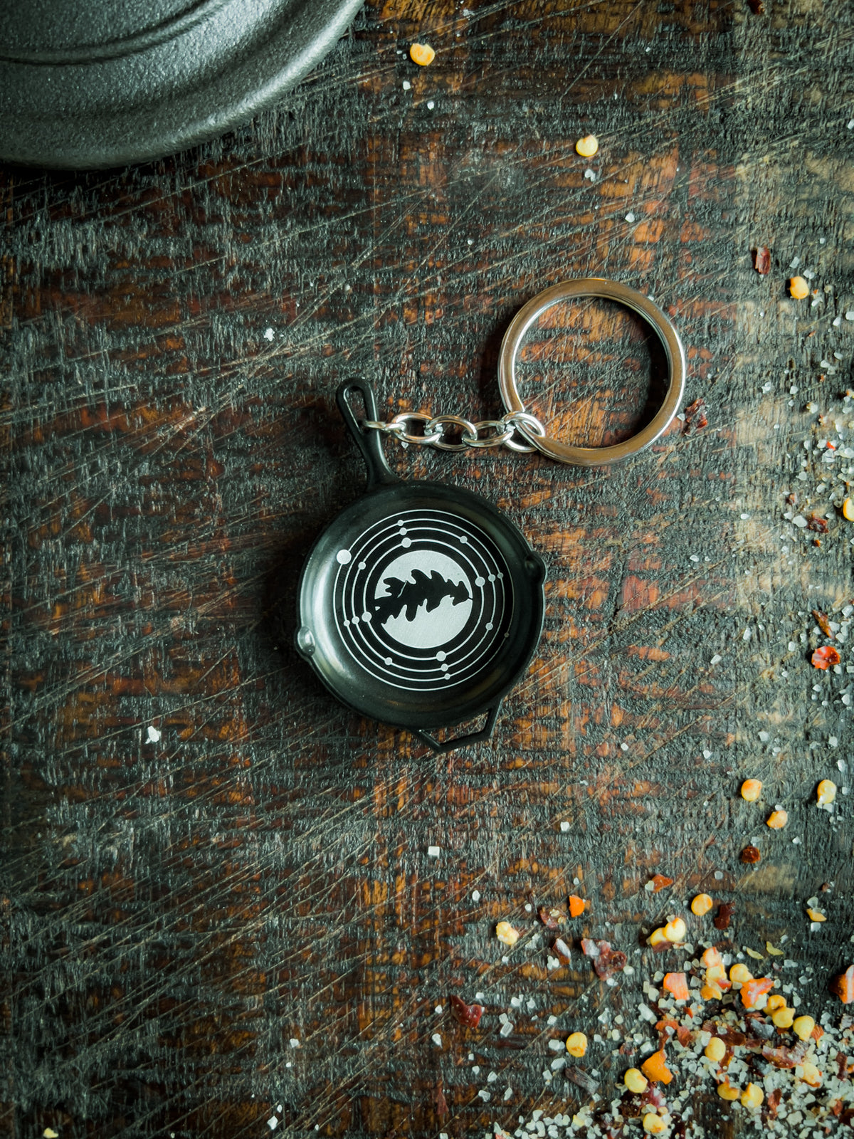 a keychain shaped like a small skillet with the dryad cookery logo engraved